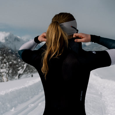 Skiier adjusting the back of the Trimtex Ace Biathlon Racesuit showing the breathable mesh fabric texture.