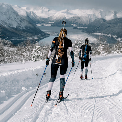 Biathletes skiing down the hill in Trimtex Biathlon Ace Racesuits.